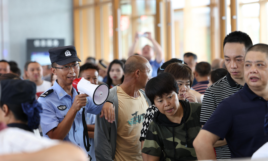 8月8日，鐵路公安民警在貴南高鐵荔波站進站口維持進站秩序。