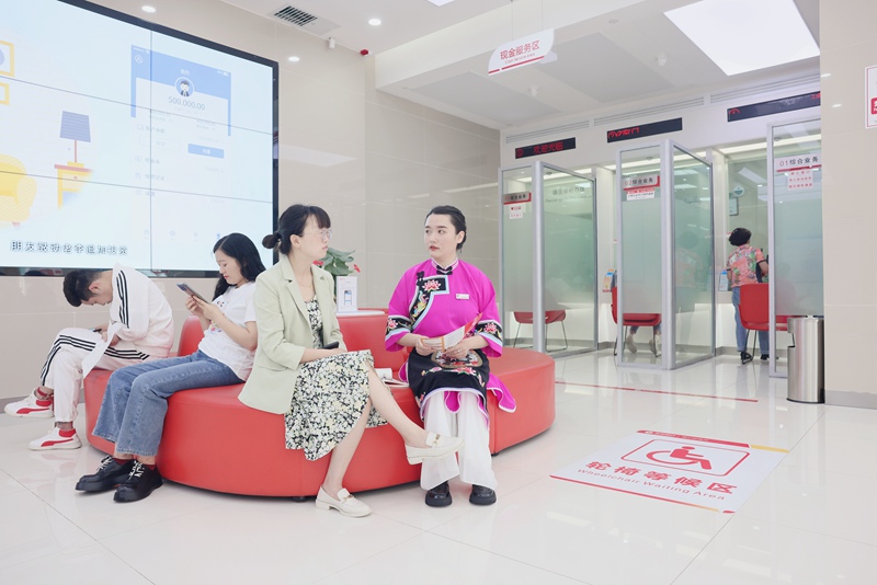 大堂经理身着屯堡装束热情服务客户。