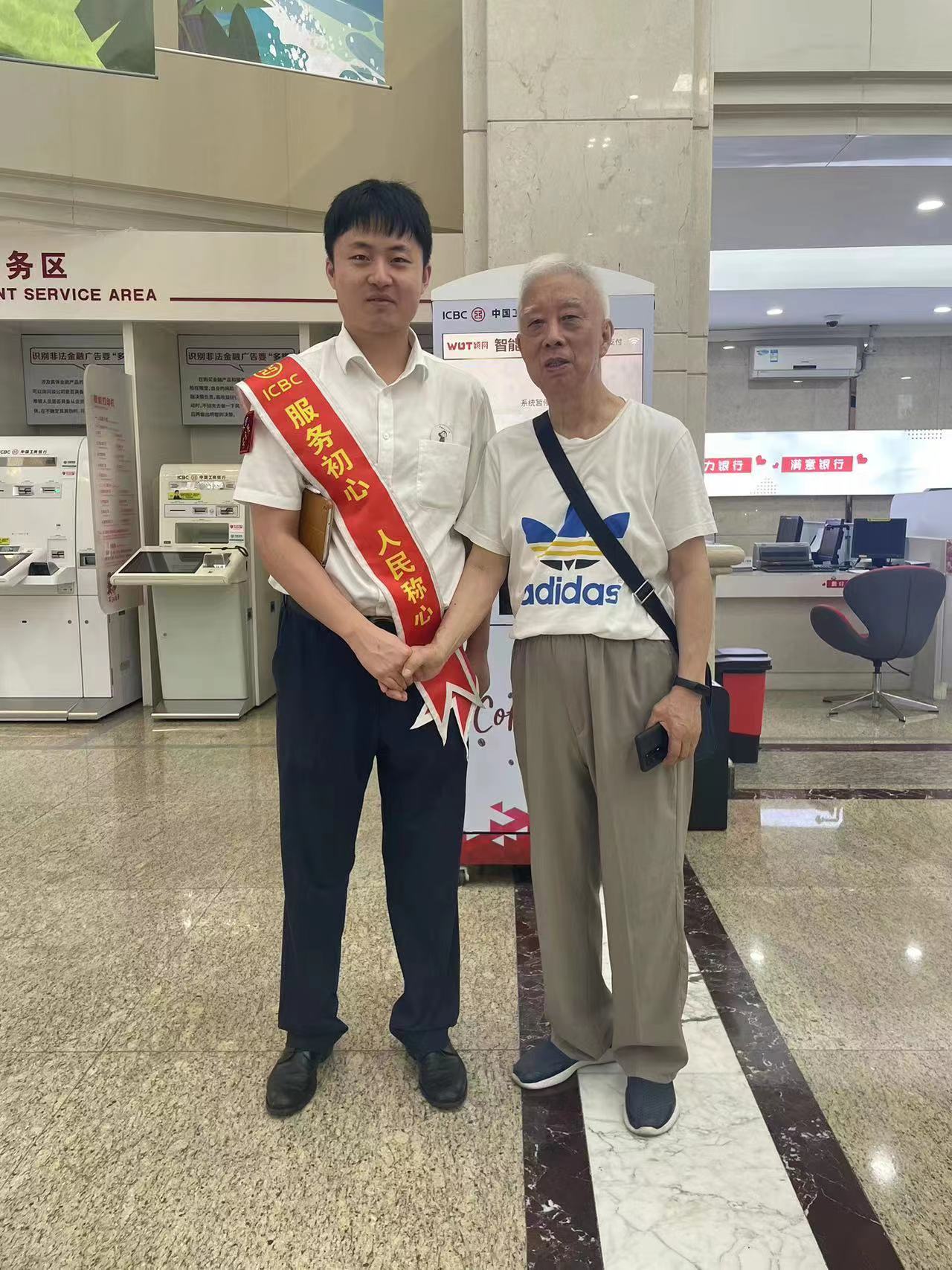 老人与工作人员合影。