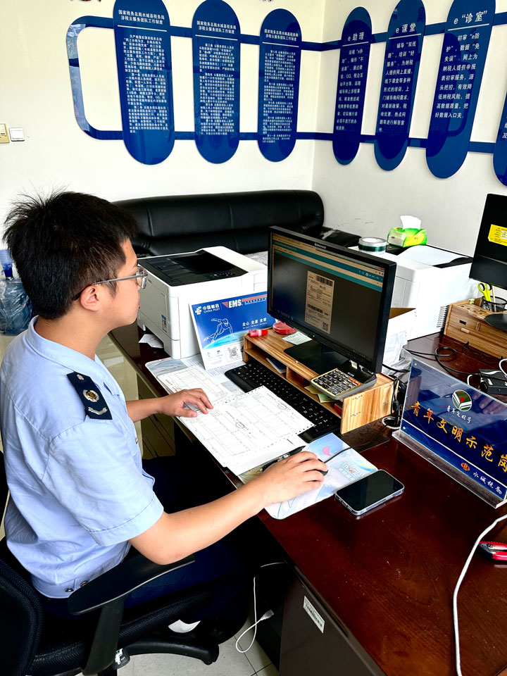 稅務e家工作人員正在為線上領用發票的納稅人辦理送票上門手續。楊詩攝