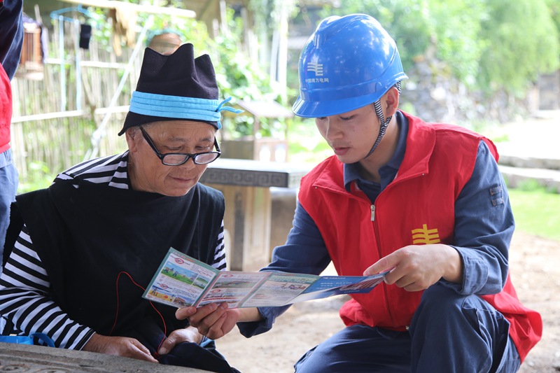 在黔南州荔波县瑶山古寨，南方电网工作人员向群众宣传节能减排和安全用电知识。王文涛  摄