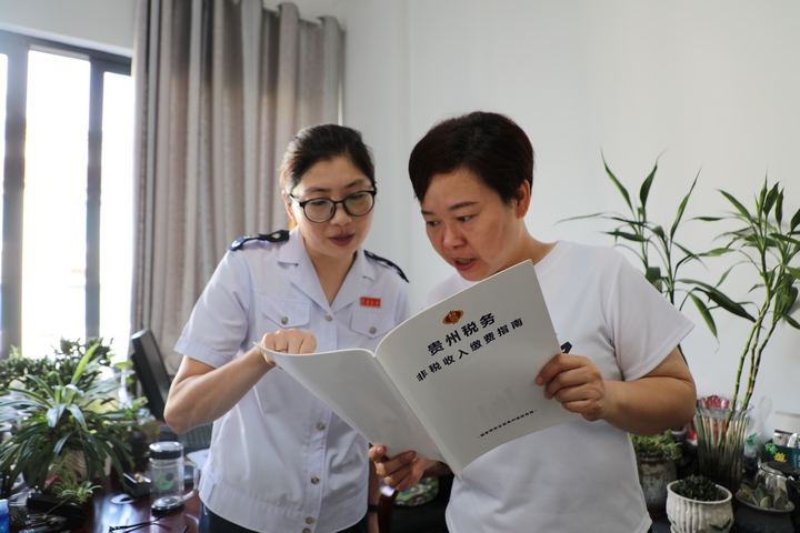 税务人员指导缴费人学习《非税收入缴费指南》。 李传会摄