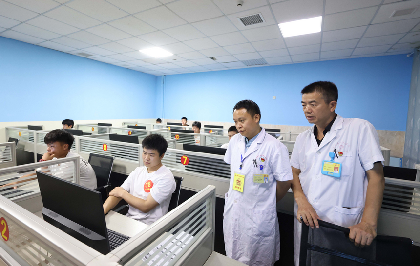 8月11日，冉茂志（右二）在玉屏侗族自治縣人民醫院查看應征青年做心理測試。