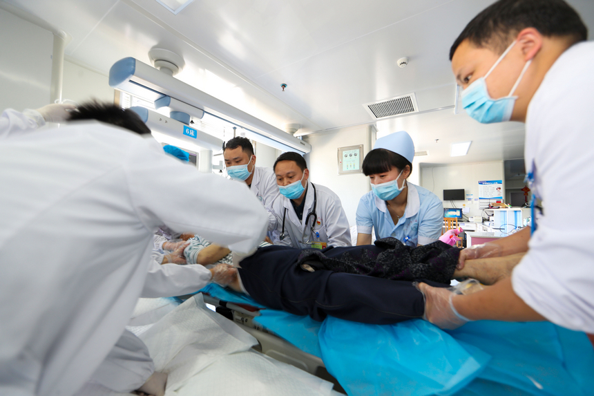 冉茂志（右三）在貴州省玉屏侗族自治縣人民醫院急救科搶救病人（2021年5月9日攝）。