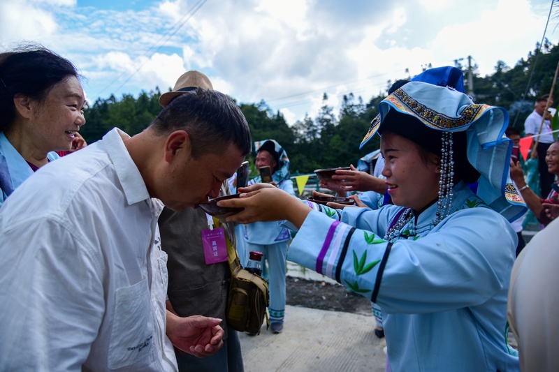 8月22日，在普底鄉紅豐村仡佬大寨當地仡佬民眾喂游客攔門酒。