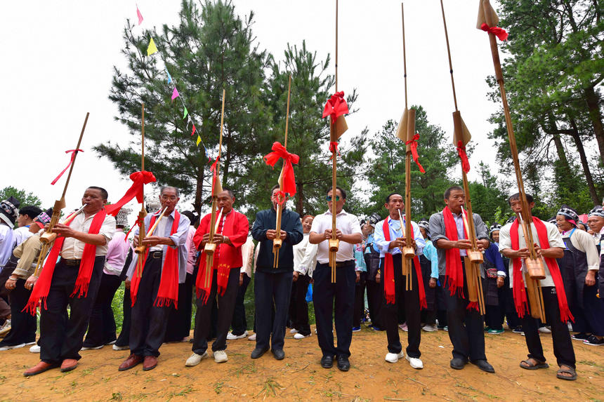 村民在“爬坡节”现场吹奏芦笙。潘皇权摄