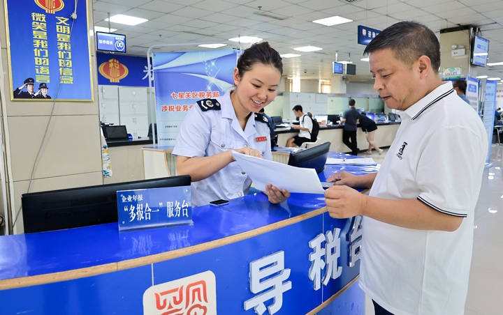 办税服务厅在咨询台设置多报合一窗口为纳税人答疑解惑。皮婷摄