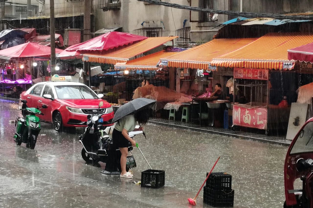 图片（5）湘雅街道工作人员冒雨疏通农贸市场堵塞下水道