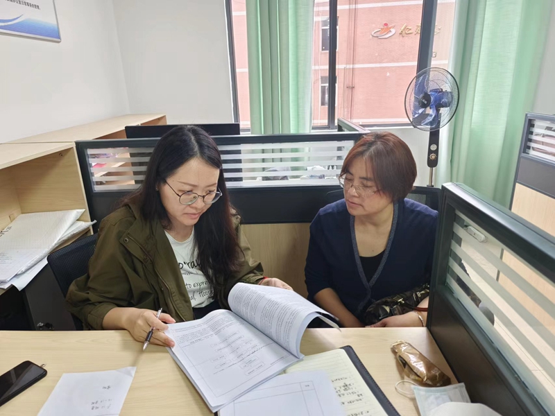 1.胡睿莹（左）与其他老师进行教育教学业务探讨。受访者供图