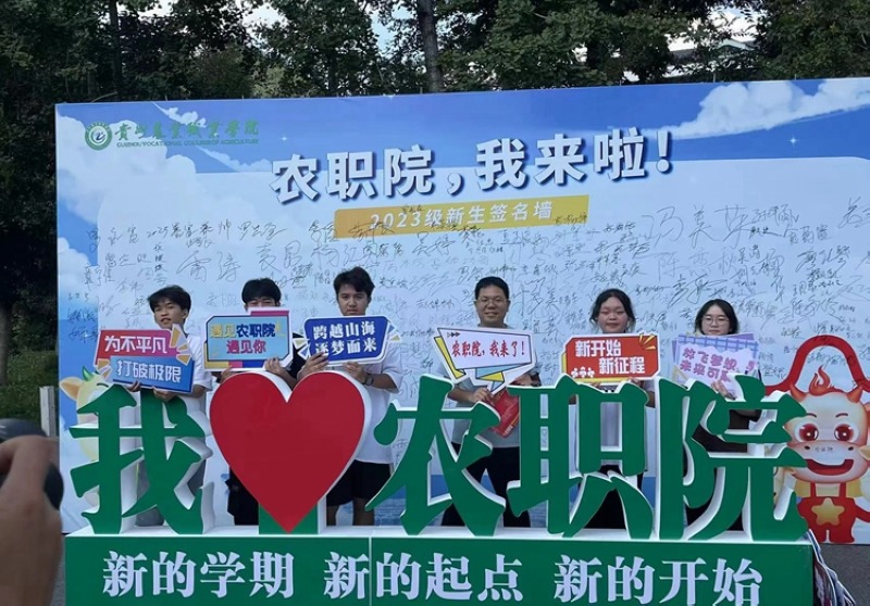新生签名墙前，龙方江留下合影。