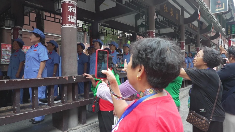 5 图为遵义红歌艺术团在红军街演出，引得游客驻足围观（周国栋  摄）.jpg