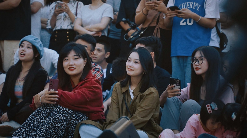 音乐会现场，观众席地而坐欣赏音乐。
