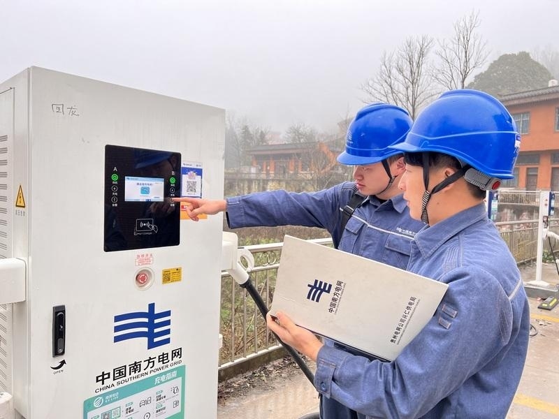 南方电网兴仁供电局工作人员对乡镇新安装的新能源充电设施进行调试。