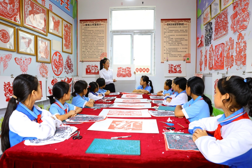 剑河县城关第三小学教师向学生讲解剪纸技巧。杨家孟摄