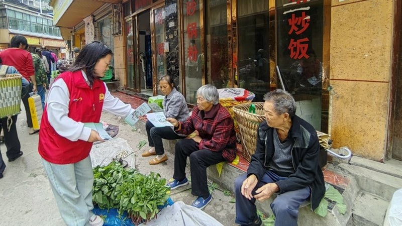志愿者正在向群众发放宣传手册 修文县六广镇--唐世芸 摄.jpeg