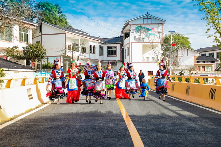 长顺县广顺镇四寨村少数民族群众穿着节日盛装走在“四好农村路”上。商茜摄