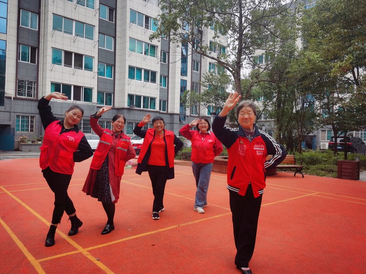 志愿者与小区居民在社区跳舞锻炼身体。