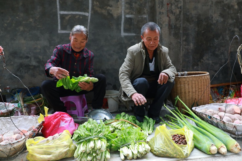 商贩杨琴兰夫妻在贩卖自己家的农特产品。