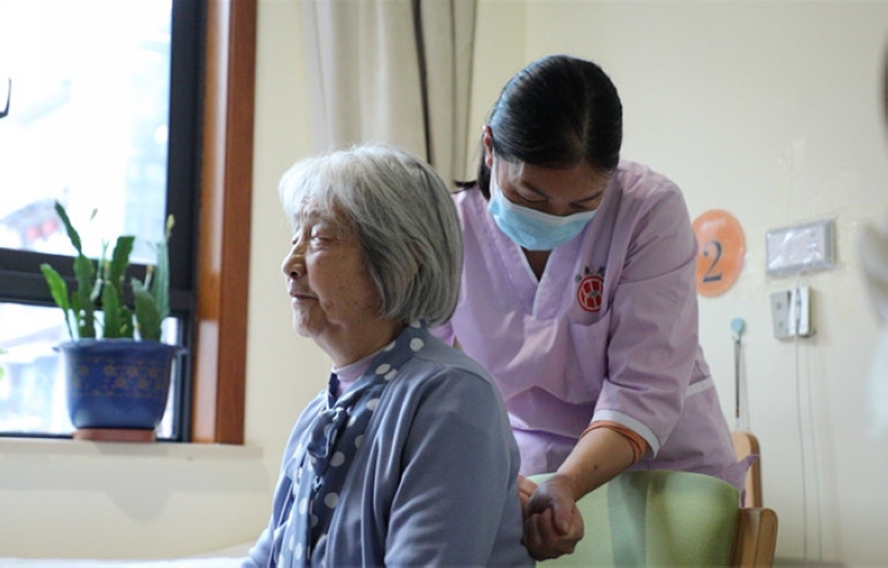 养老机构工作人员正在为老人捶背。李甜甜摄