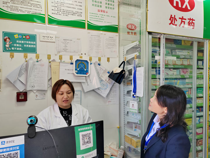 工作人员检查零售药店相关手续。