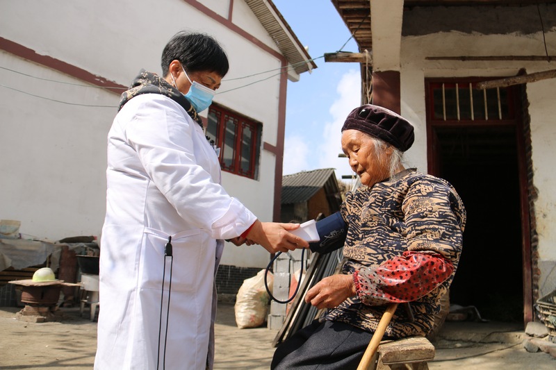 村医到村民家中为村民量血压。