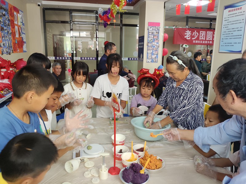 图为：东湖社区组织辖区老人孩子一起开展丰富多彩的文体活动。