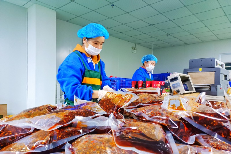 贵州卡妈农特产品开发有限公司生产车间内工人们正在打包产品。