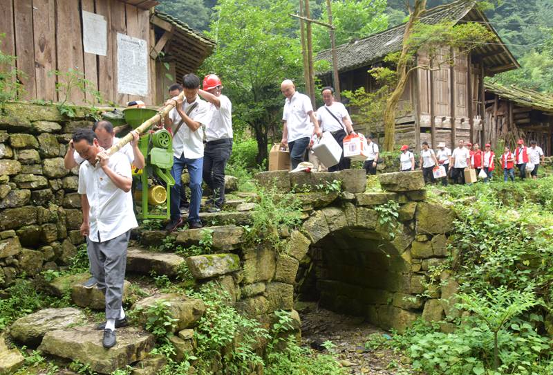 山洞组通电当天，“天坑党员服务队为村民赠送打米机等家用电器。
