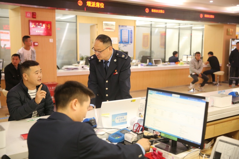 图为李坤在盘州市政务服务中心全程陪同纳税人办理涉税业务。夏邦晟摄