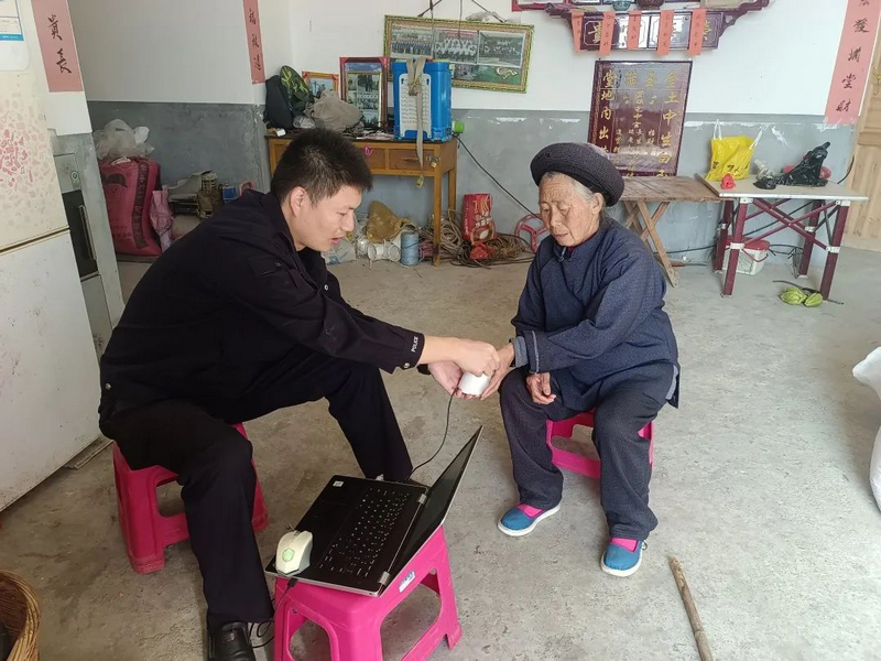 民警帮老人采集指纹。麻山中心派出所供图