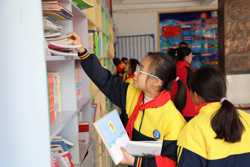 同学们在读书角阅览图书。