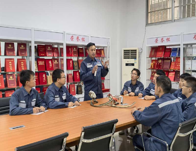 南方电网兴义供电局创新工匠龙福刚向青年员工介绍工作室创新工器具的发明理论。