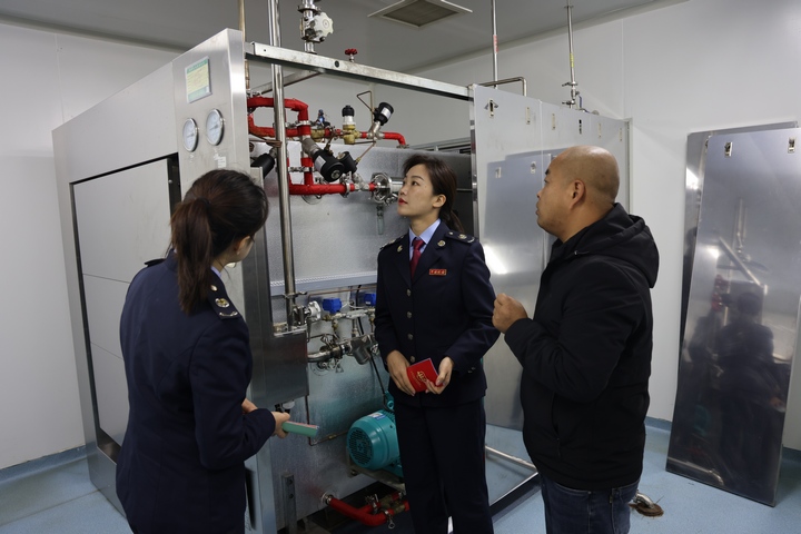 税务干部在贵州同威生物科技有限公司生产车间了解其冷冻干燥技术。漆毓摄