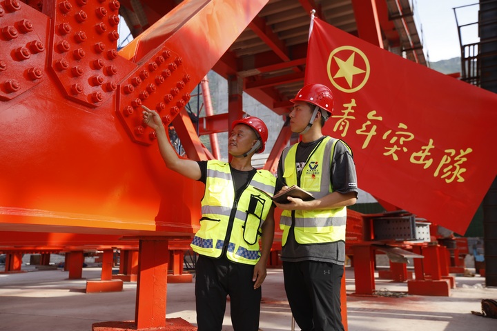 图为突击队员讨论牂牁江大桥钢桁梁拼接工艺。