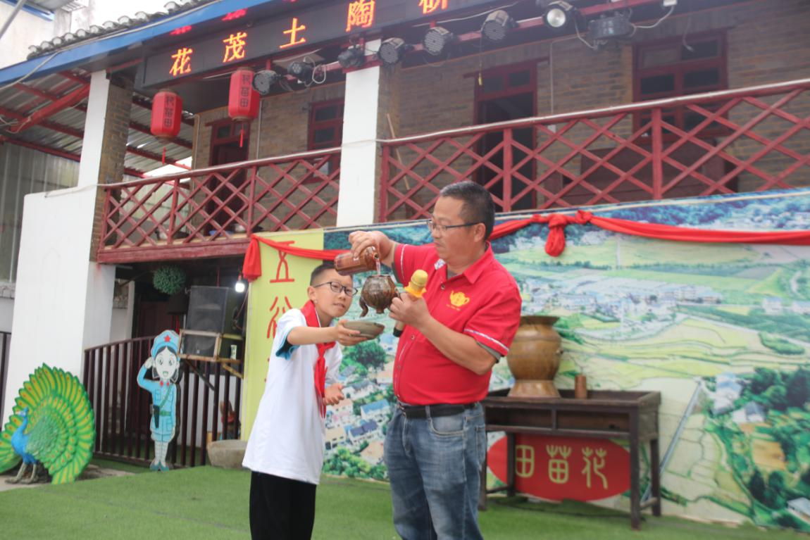 图为杨波在向学生展示花茂特色陶罐的有趣功能。