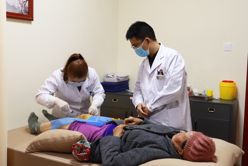 图为在宋江明的指导下，王庄乡卫生院医务人员正在对患者进行治疗。（李齐 摄）.jpg