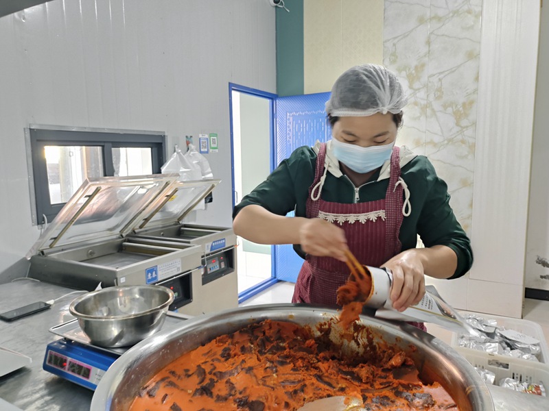 3、桐梓县李仕昌食品有限公司的工作人员正在将炒制好的羊肉进行包装。曹园园摄