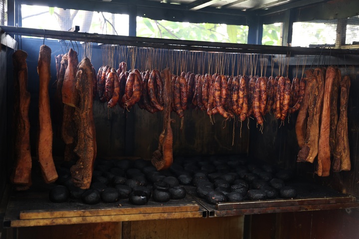 正在用柴火熏烤的腊肉、香肠、血豆腐。