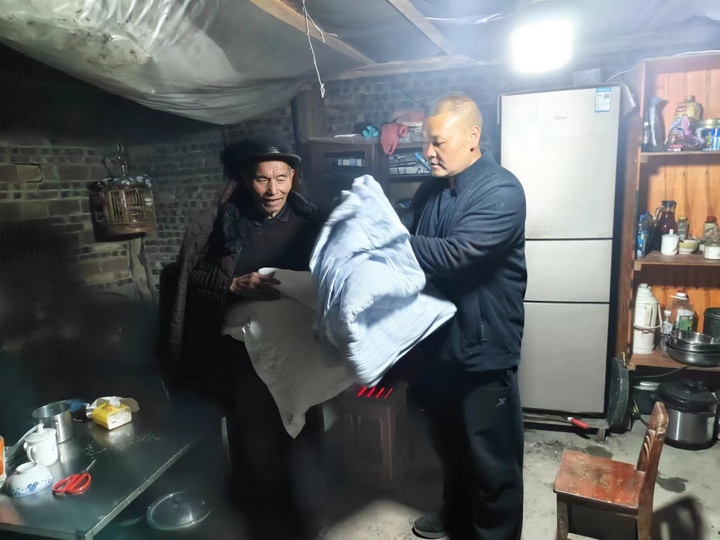李雲（右）為村民送去保暖物資。貴旅集團供圖