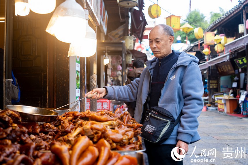 游客在古镇内挑选当地特色美食。人民网记者 涂敏摄