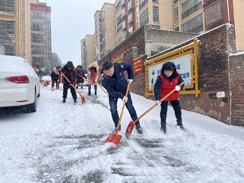 圖為:硒城街道干田壩社區黨員及志願者開展鏟冰除雪