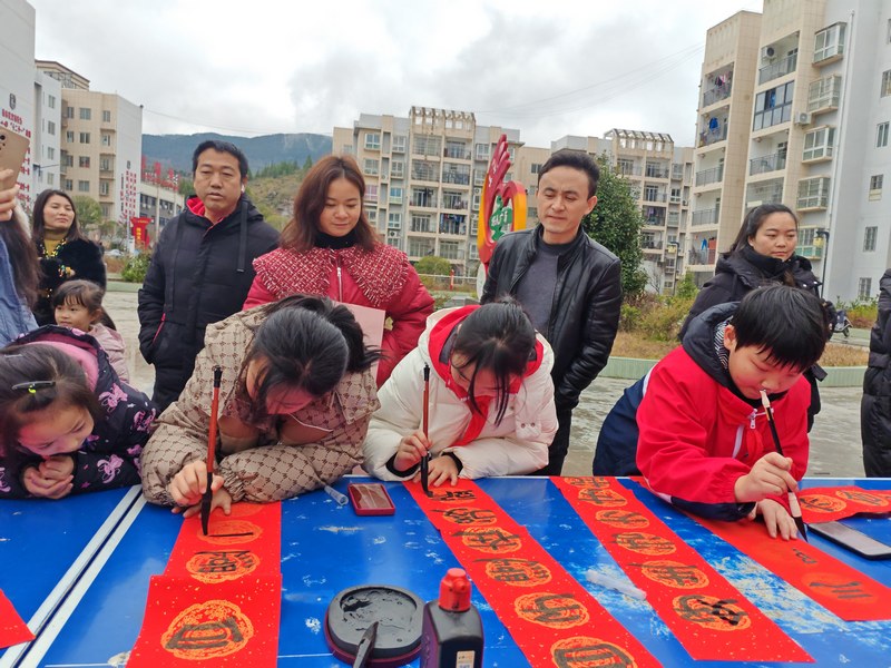 活动现场学生们正在写春联（杨名强 摄）.jpg