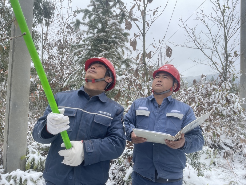 南方电网兴仁供电局工作人员使用绝缘杆对覆冰台区进行处理。