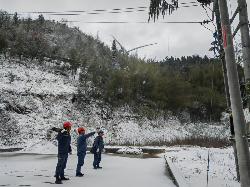南方电网兴仁供电局工作人员对凝冻覆雪台区进行温度检测。