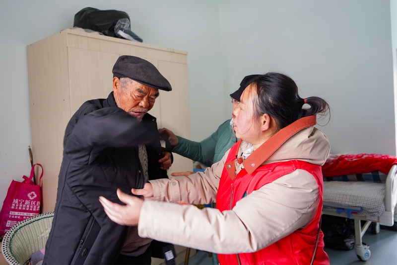 1月22日，在威寧自治縣中心敬老院，工作人員在給老人換棉衣。趙慶能攝