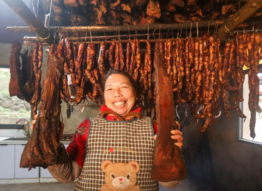 2024年1月19日，村民在貴州省黔東南苗族侗族自治州施秉縣城關鎮雲台村展示剛熏烤好的臘肉。