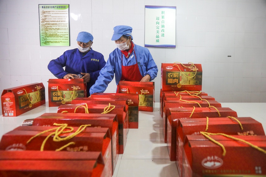 2024年1月19日，工人在貴州省黔東南苗族侗族自治州施秉縣一家臘肉加工企業車間包裝臘肉。