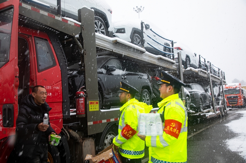 1月22日，过境车辆滞留在S30江黔高速安江段花桥服务区，石阡交通部门为滞留人员送去暖心包。余明江摄