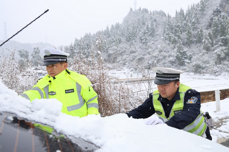雪地裡幫助受困打滑車輛，交警抗凝保暢一線卡點堅守。
