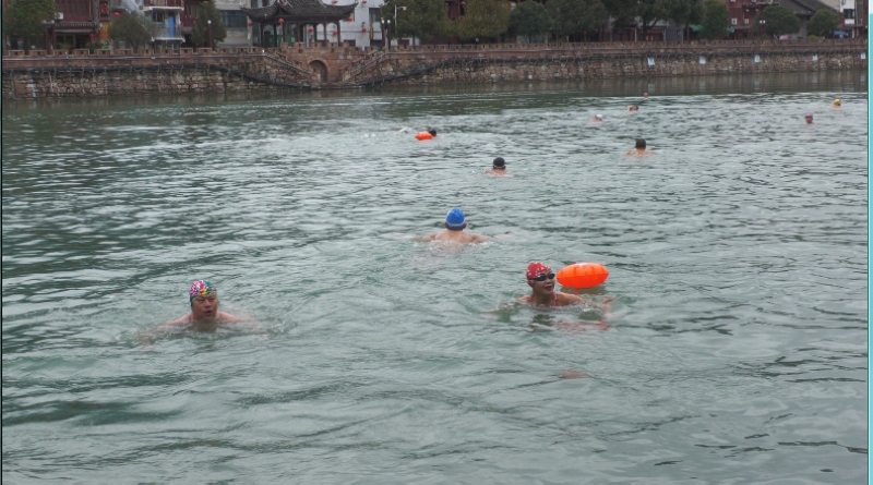 游泳爱好者们在龙川河里冬泳。